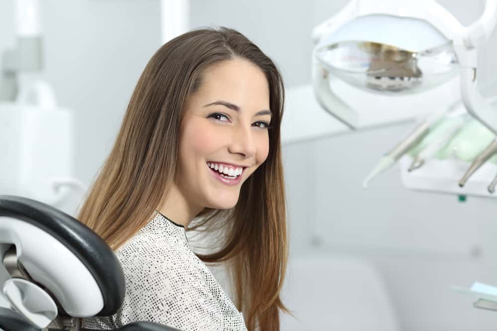 Satisfied,Dentist,Patient,Showing,Her,Perfect,Smile,After,Treatment,In